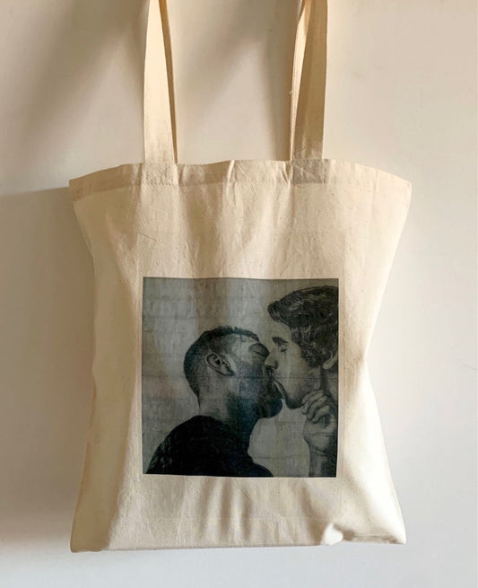 close up view of a tote bag printed with an image of a drawing by the artist James Robert Morrison that depicts two men (Javier and Marc) kissing passionately