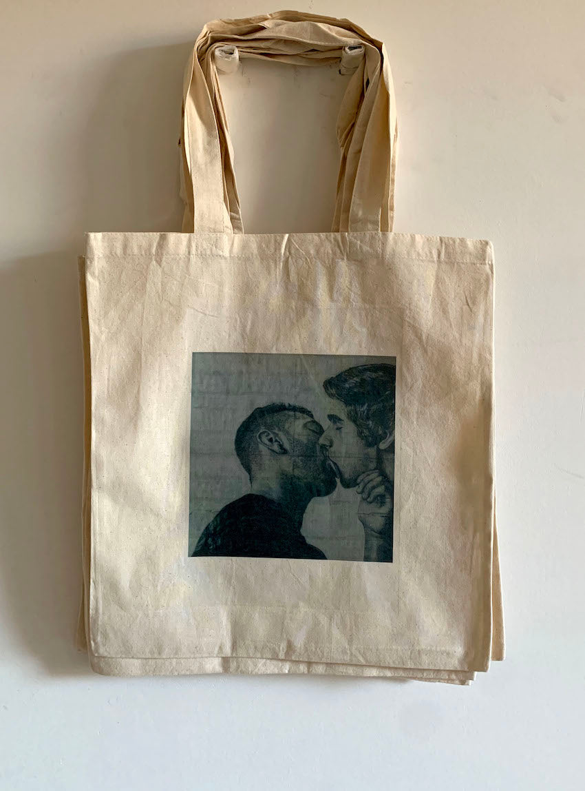 full view of a tote bag printed with an image of a drawing by the artist James Robert Morrison that depicts two men (Javier and Marc) kissing passionately
