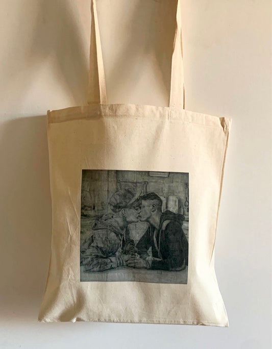 close up view of a tote bag printed with an image of a drawing by the artist James Robert Morrison that depicts two men (Kieron and Wayne) sat together at a table holding hands and kissing