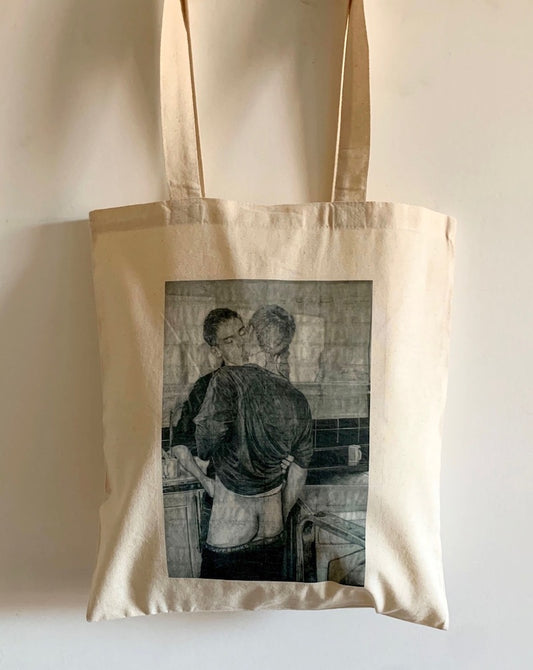 close up view of a tote bag printed with an image of a drawing by the artist James Robert Morrison that depicts two men (Peter and Geoff) kissing, one of them with his bare bottom on show